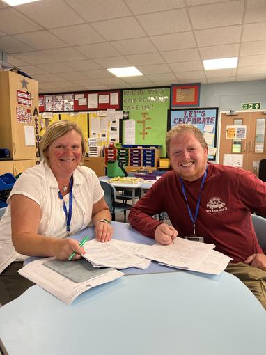Sue Palmer and Scott Tyler sat at a desk smiling to camera